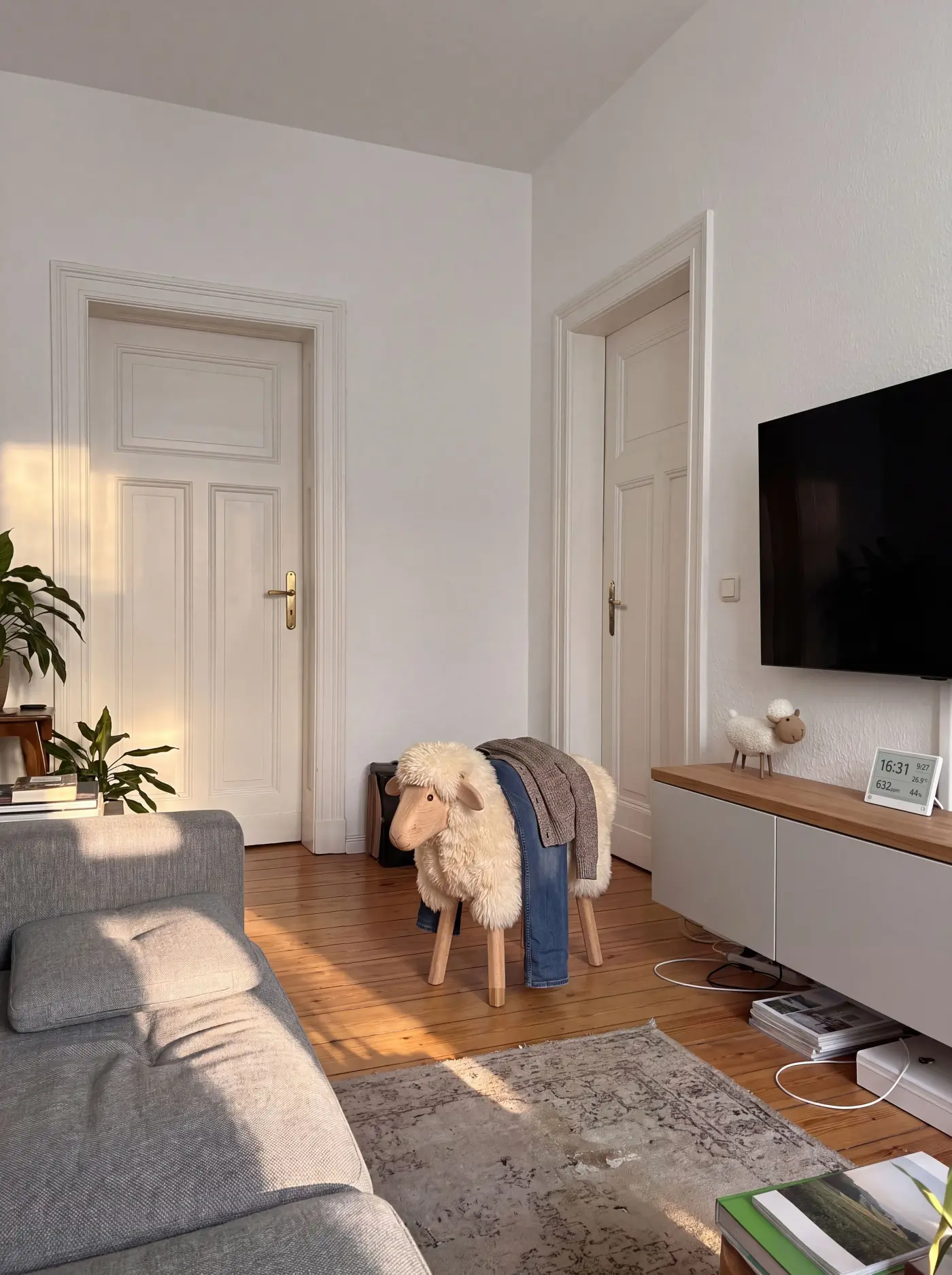The living room of the flat, with a wooden sheep stool in the middle